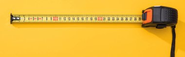 Top view of industrial measuring tape on yellow background, panoramic shot clipart