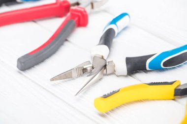 Beyaz ahşap arka planda metal pense görüntüsünü kapat