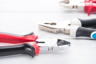 Beyaz ahşap yüzeydeki metal kerpetenin yakın görüntüsü