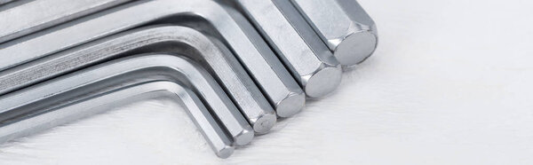 Close up view of hex keys on white wooden background, panoramic shot