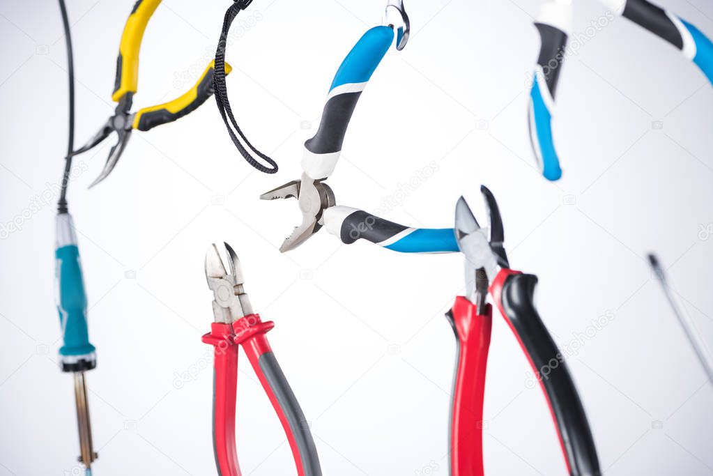 Selective focus of pliers and tools levitating in air isolated on grey