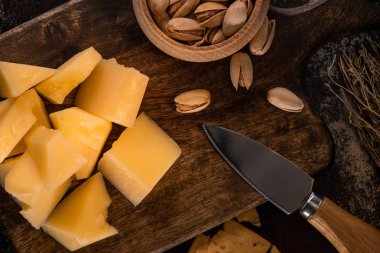 Grana Padano ve bıçağın yanındaki fıstıklı peynir tabağının en üst görüntüsü.