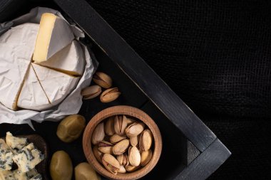 Tepsinin tepsisinin tepsisi, kaymak peyniri ve dorblu, kurutulmuş zeytin ve siyah üzerine izole edilmiş şam fıstığı parçaları. 