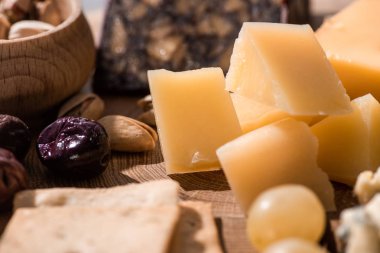Tahta arka planda grana padano, kraker, zeytin ve şam fıstığı seçmeli odağı