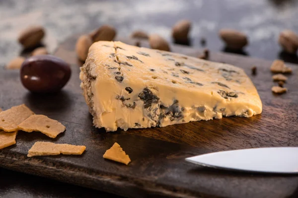木製のまな板の上にクラッカーとナイフでドルブルチーズの近景 — ストック写真