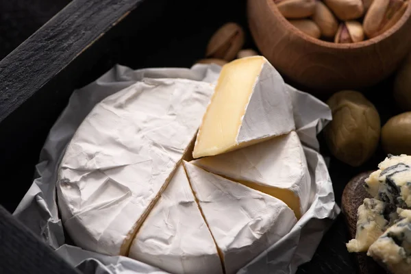 Camembert Darabok Szelektív Fókusza Dorbluval Szárított Olajbogyóval Pisztáciával Tálcán — Stock Fotó