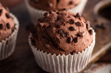 close up view of fresh chocolate muffin on wooden cutting board