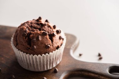 close up view of fresh chocolate muffin on wooden cutting board