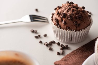 close up view of fresh chocolate muffin near fork