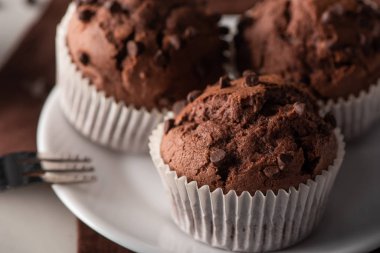 close up view of fresh chocolate muffins on white plate