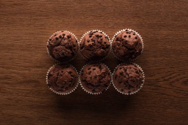 flat lay with fresh chocolate muffins on wooden surface