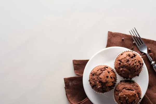 Vista Superior Muffins Chocolate Fresco Placa Branca Guardanapo Marrom Perto — Fotografia de Stock