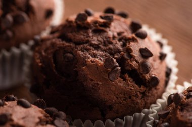 close up view of fresh chocolate muffin on wooden surface