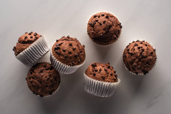 top view of fresh chocolate muffins on marble surface