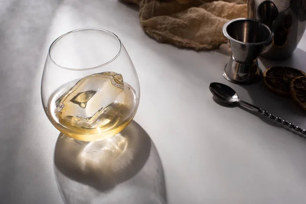 Vidrio Transparente Con Cubo Hielo Whisky Sobre Mesa Blanca Con — Foto de Stock