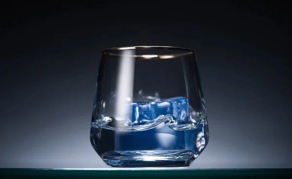 Transparant Glas Met Ijsblokjes Wodka Het Donker Met Blauwe Achtergrondverlichting — Stockfoto