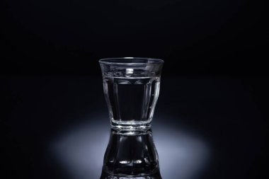 transparent glass with liquid on black background clipart