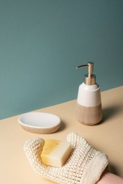 Cropped view of woman holding soap above surface near dispenser, soap dish on beige and grey, zero waste concept clipart