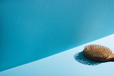 Mavi arka planda ahşap saç fırçası, sıfır atık kavramı