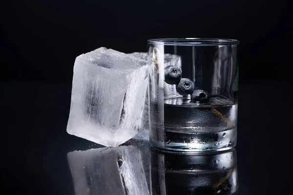 Vidro Transparente Com Vodka Mirtilos Perto Cubos Gelo Fundo Preto — Fotografia de Stock