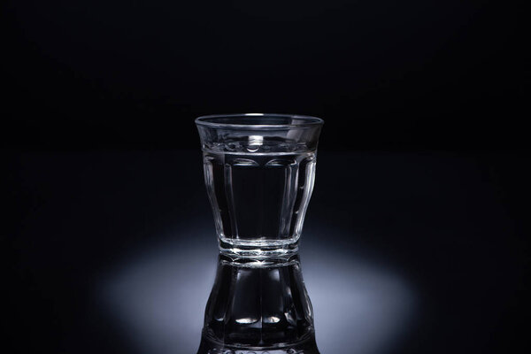 transparent glass with liquid on black background