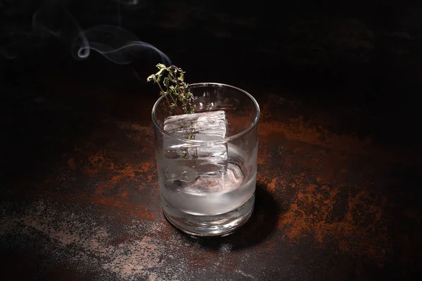 Yanan Bitkilerle Şeffaf Cam Buz Küpü Yıpranmış Yüzeyde Votka — Stok fotoğraf