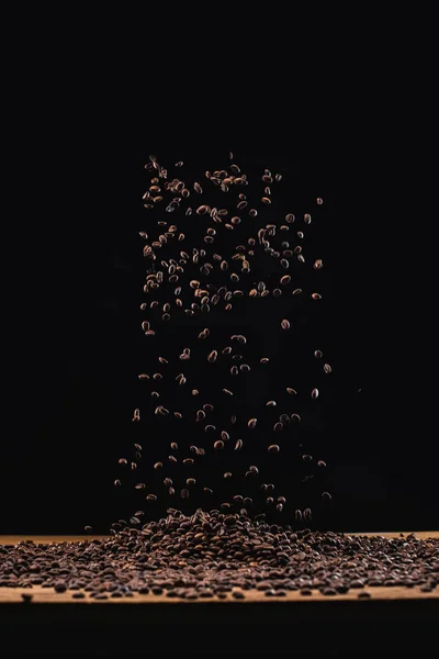Kavrulmuş Kahve Çekirdekleri Yığınında Havada Siyah Üzerine Izole Edilmiş — Stok fotoğraf