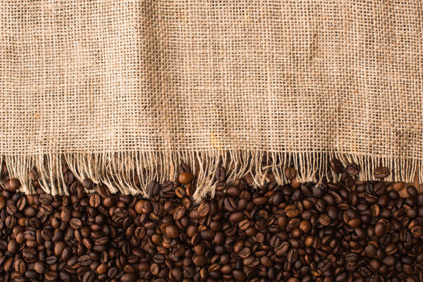 top view of fresh roasted coffee beans and sackcloth