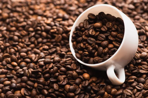 新鮮な焙煎コーヒー豆と白カップの選択的な焦点 — ストック写真