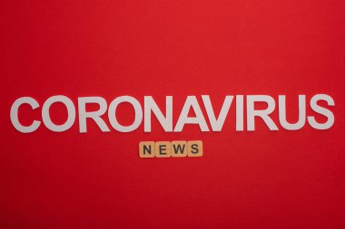 Tahta küpler ve kırmızı arkaplanda koronavirüs harfleri ile ilgili haber bültenlerinin en üst görüntüsü