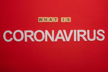 Kırmızı arkaplandaki koronavirüs kelimesinin üst görünümü