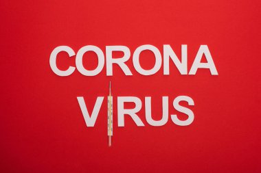 Kırmızı üzerine izole termometre ile Coronavirus harflerinin üst görünümü