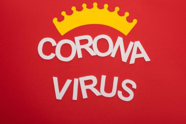 Koronavirüs harflerinin üst görüntüsü kırmızı üzerine izole edilmiş taç.