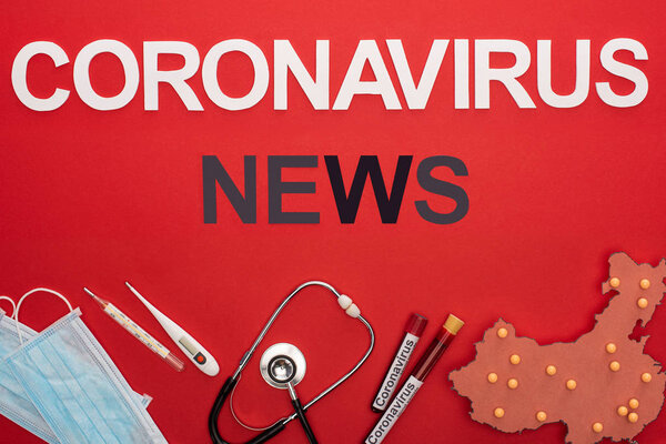 Top view of coronavirus news lettering with medical equipment and layout of china map on red surface