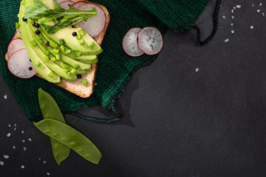 Avokado, pırasa ve kumaş üzerinde turplu tost manzarası.