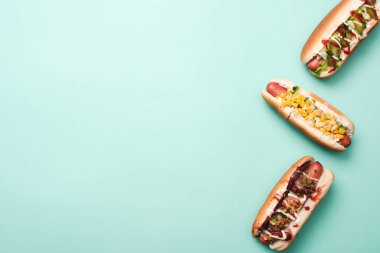 top view of three hot dogs on blue