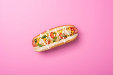 Pembe ekmekli lezzetli bir sosislinin üst görüntüsü.