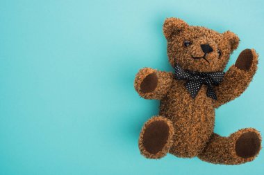 Mavi arka planda fiyonklu oyuncak ayının üst görüntüsü