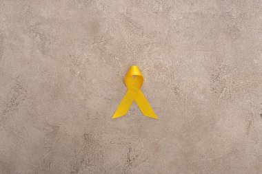 Top view of yellow ribbon on grey background, international childhood cancer day concept clipart