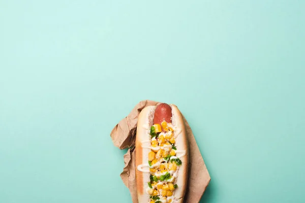 用蓝色纸包着玉米的美味热狗的顶部视图 — 图库照片