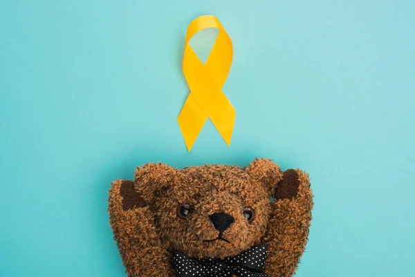 Top View Yellow Ribbon Brown Teddy Bear Blue Background International — Stock Photo, Image