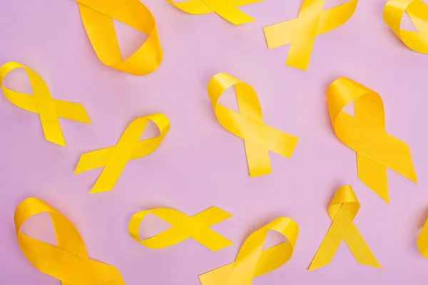 紫色の背景に黄色のリボンのトップビュー 国際小児がんの日の概念 — ストック写真