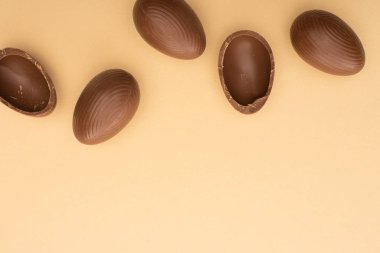 Bej arka planda çikolatalı yumurtaların üst görüntüsü