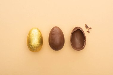 Top view of chocolate easter eggs on beige background clipart