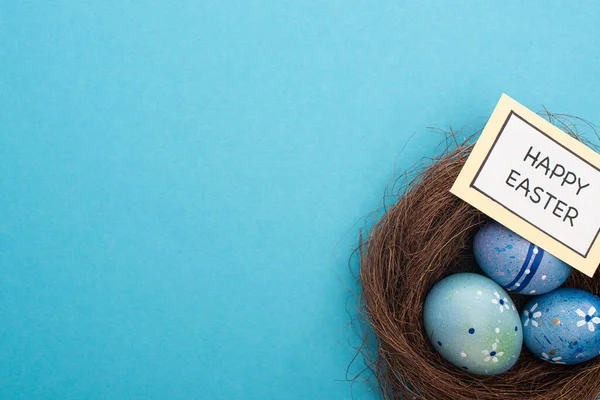 Вид Сверху Гнездо Пасхальными Яйцами Открыткой Поздравлением Пасхой Синем Фоне — стоковое фото