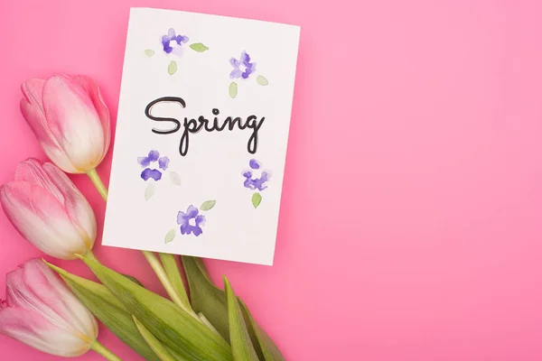 ピンクの背景に春のレタリングと花やカードのトップビュー — ストック写真