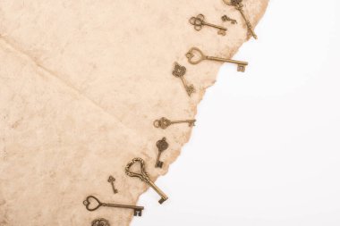 top view of vintage keys on aged paper isolated on white clipart