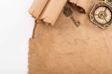 Beyaz üzerine izole edilmiş eski kağıt üzerindeki eski anahtar ve pusula üst görünümü