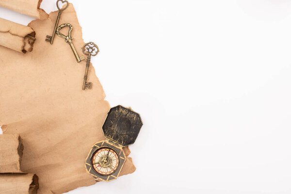 вид сверху на винтажный компас, ключи и старую пергаментную бумагу, изолированную на белом
