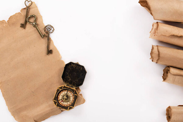 вид сверху на винтажный компас, ключи и старую пергаментную бумагу, изолированную на белом

